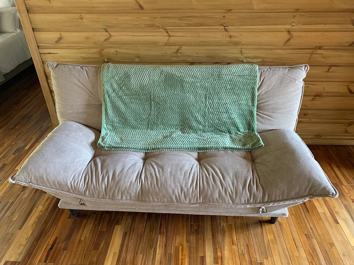 Le clic-clac deux places avec son plaid vert sur le parquet