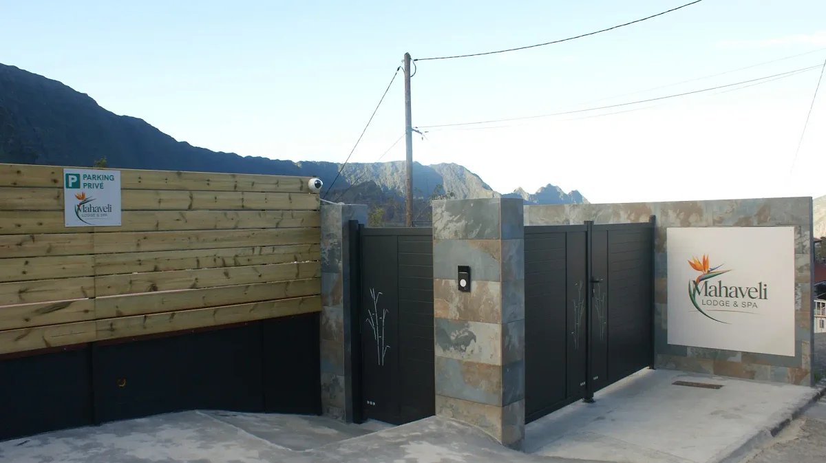 L'entrée du Mahaveli, son portail noir et son mur de pierre et de bois, au pied des montagnes