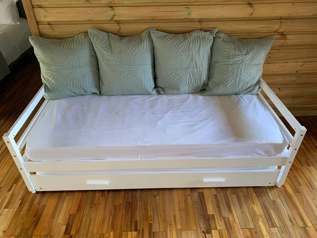 Les lits gigognes blancs avec leurs coussins verts