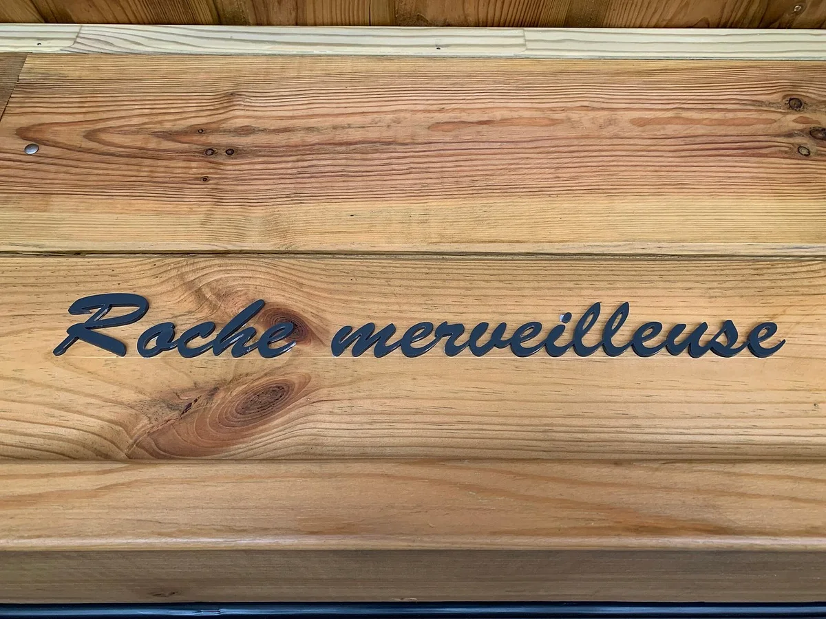La plaque de bois gravée « Roche merveilleuse » à l'entrée du lodge