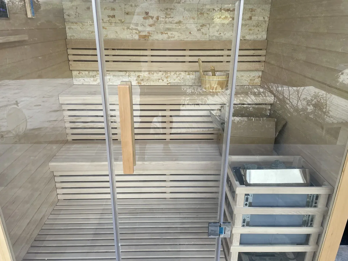 Le sauna en bois clair et son poêle