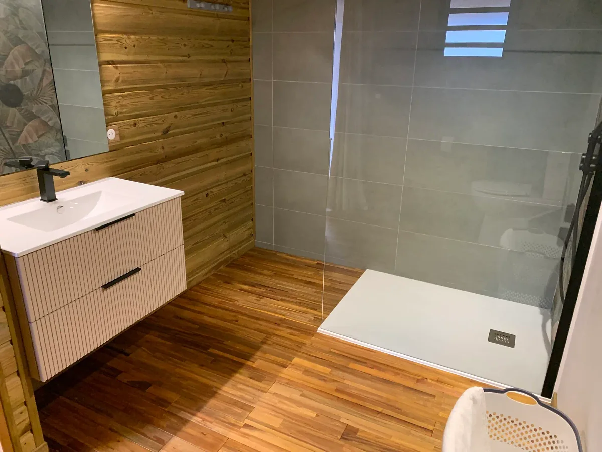 La salle de bains, son meuble vasque et la douche à l'italienne vitrée