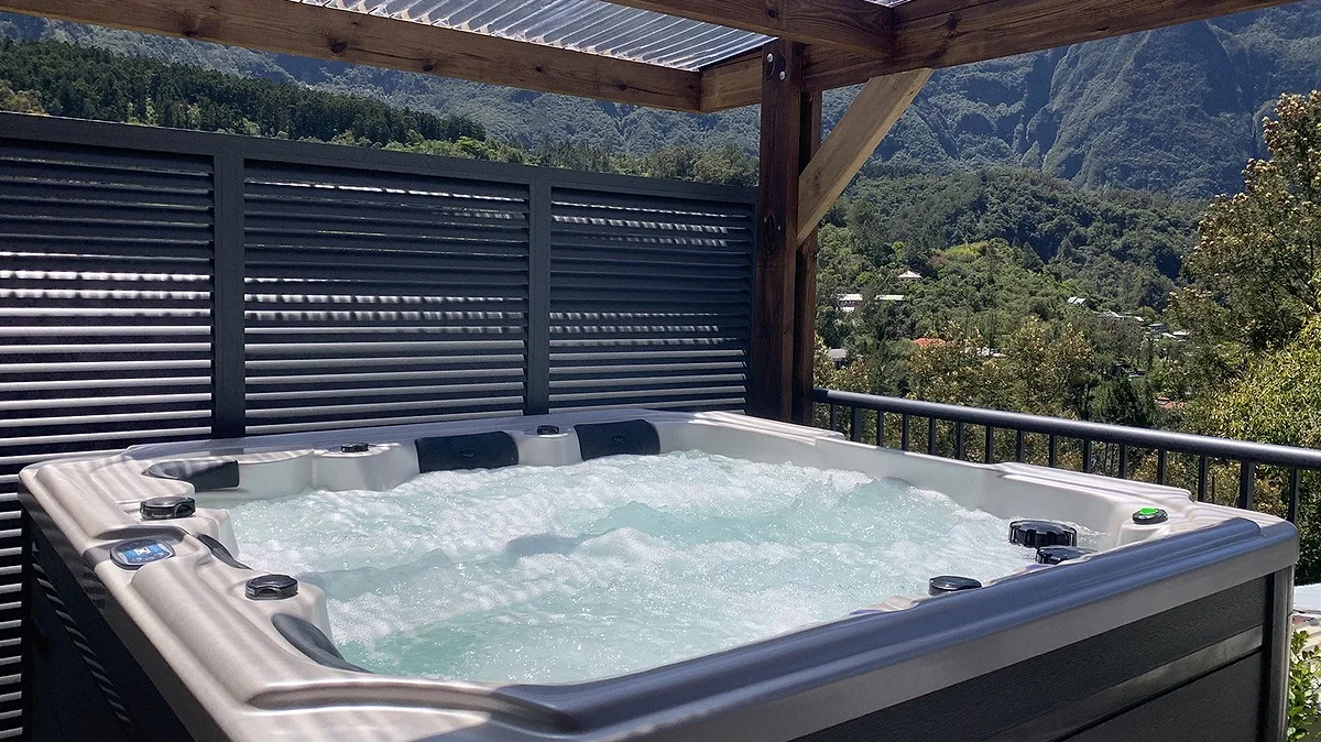 Le jacuzzi sous son abri de bois, face aux montagnes
